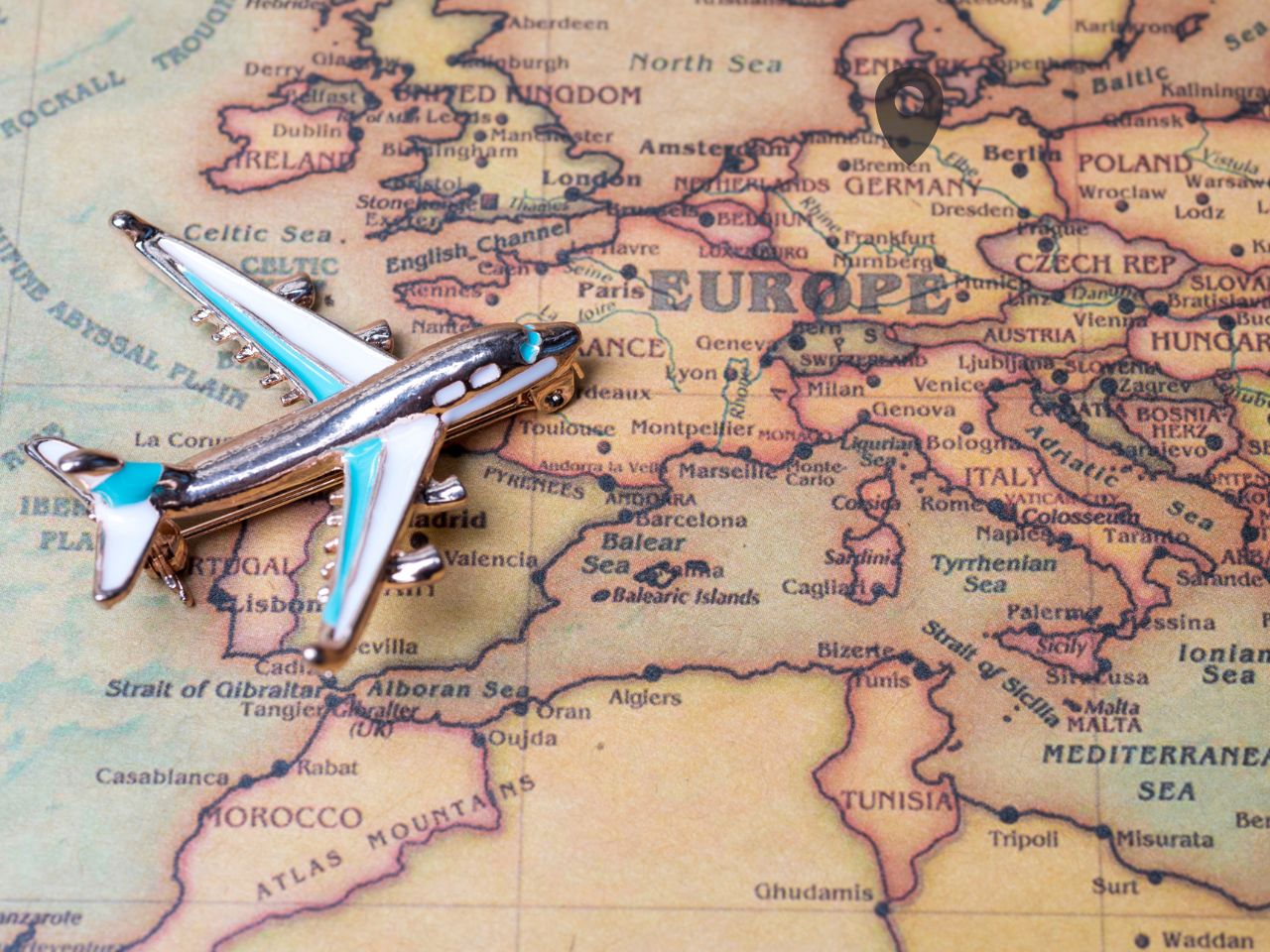 A miniature airplane placed on a vintage-style map of Europe, highlighting Germany as a travel destination
